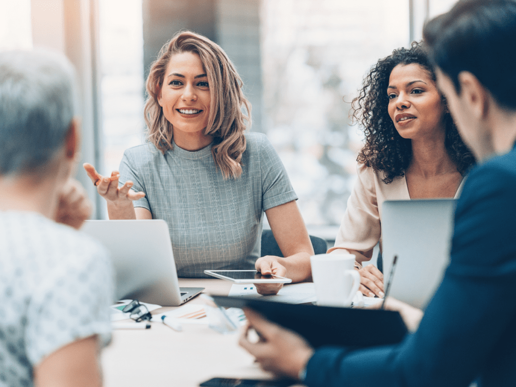 colleagues sitting around a table discussing work 