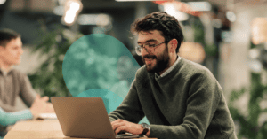 Featured image of a man sitting at a computer smiling